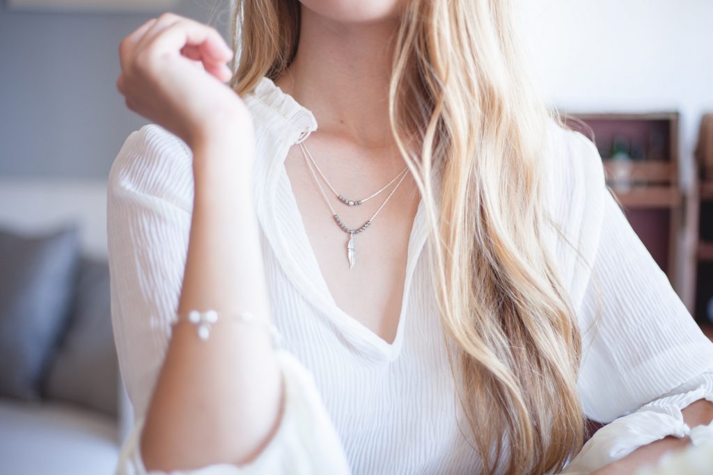 necklaces layered with a V-neck shirt