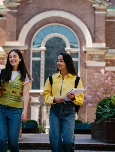 College Girl Walking with Their Notes and Smiling