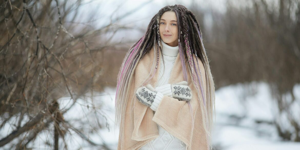 woman in pink long sleeve shirt and white skirt standing on snow covered ground during daytime