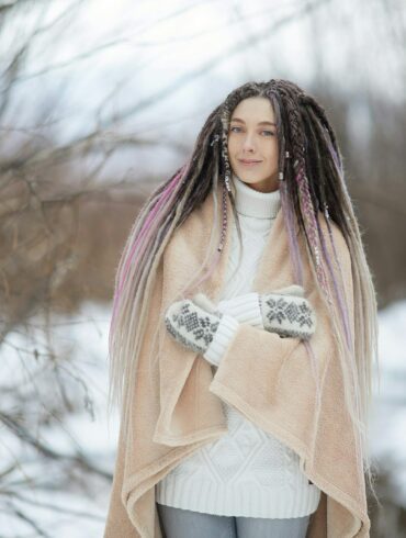 woman in pink long sleeve shirt and white skirt standing on snow covered ground during daytime