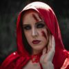 Woman in red hood with fake bruise and cut makeup on her face