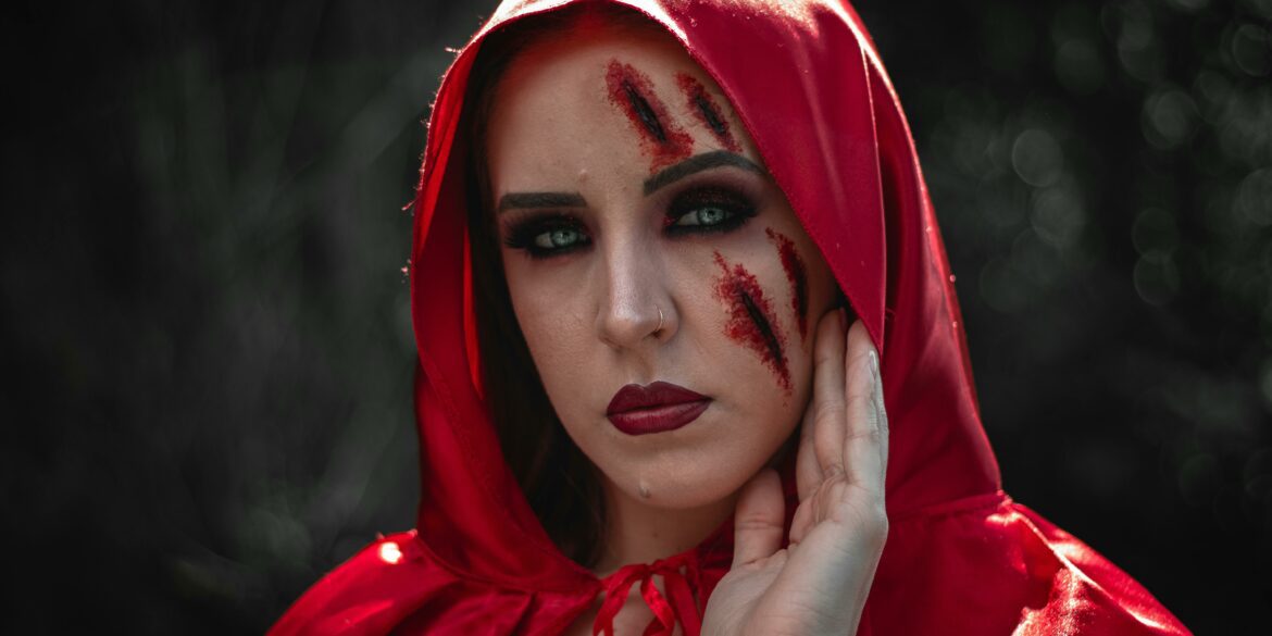 Woman in red hood with fake bruise and cut makeup on her face